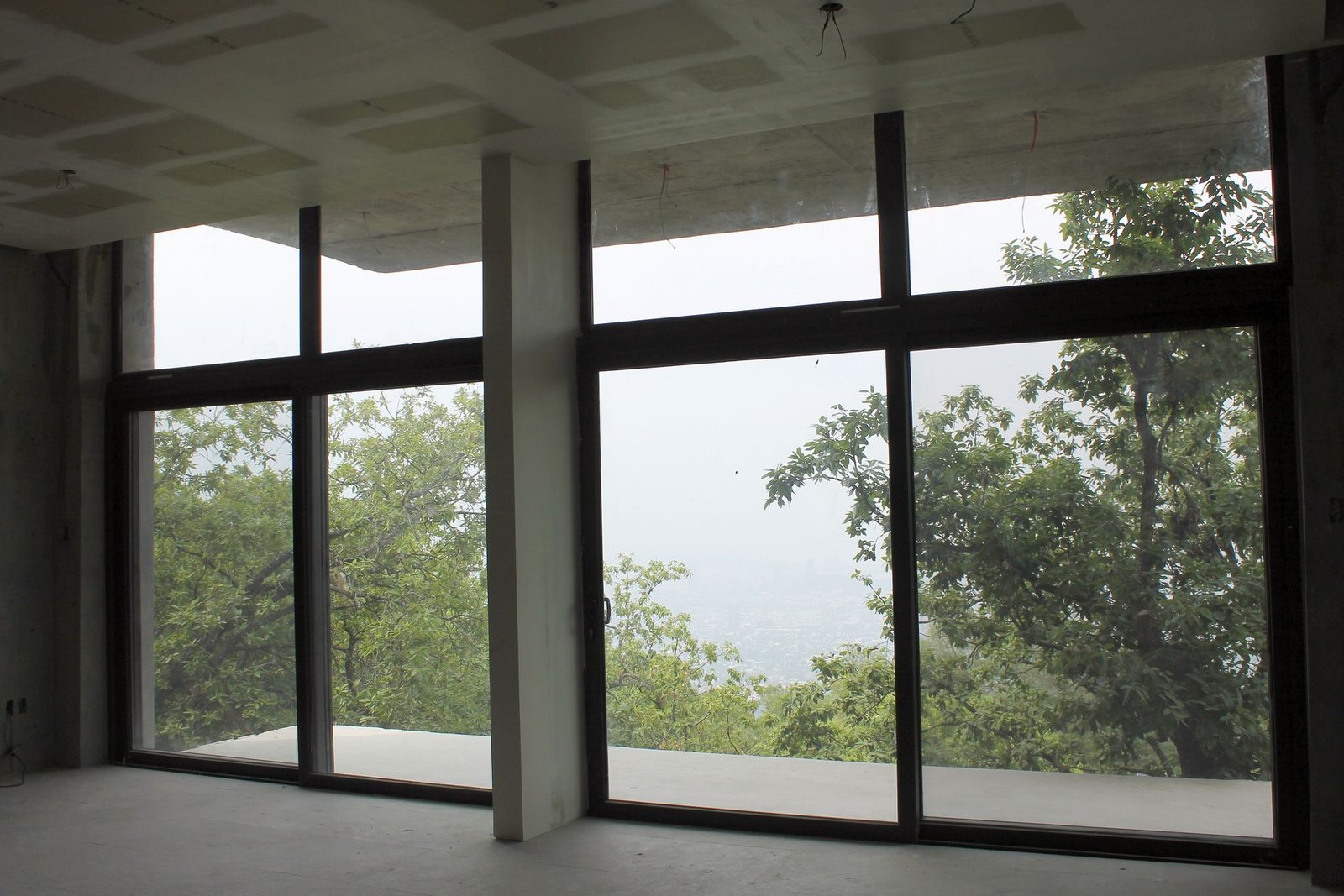 Sala con ventanales de piso a techo abiertos al valle desde la ladera de Chipinque